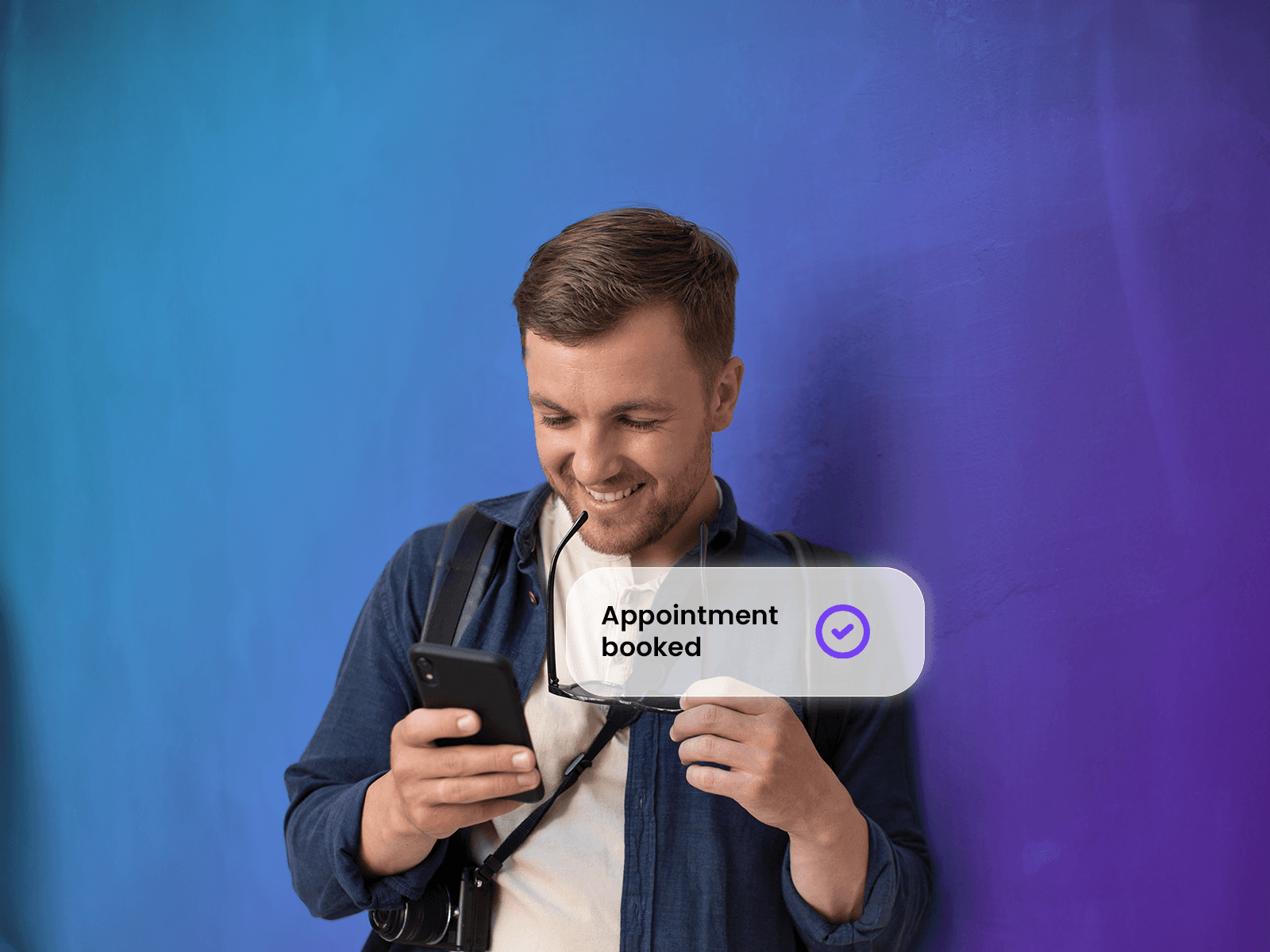 A man is holding a smartphone displaying a successfully created appointment